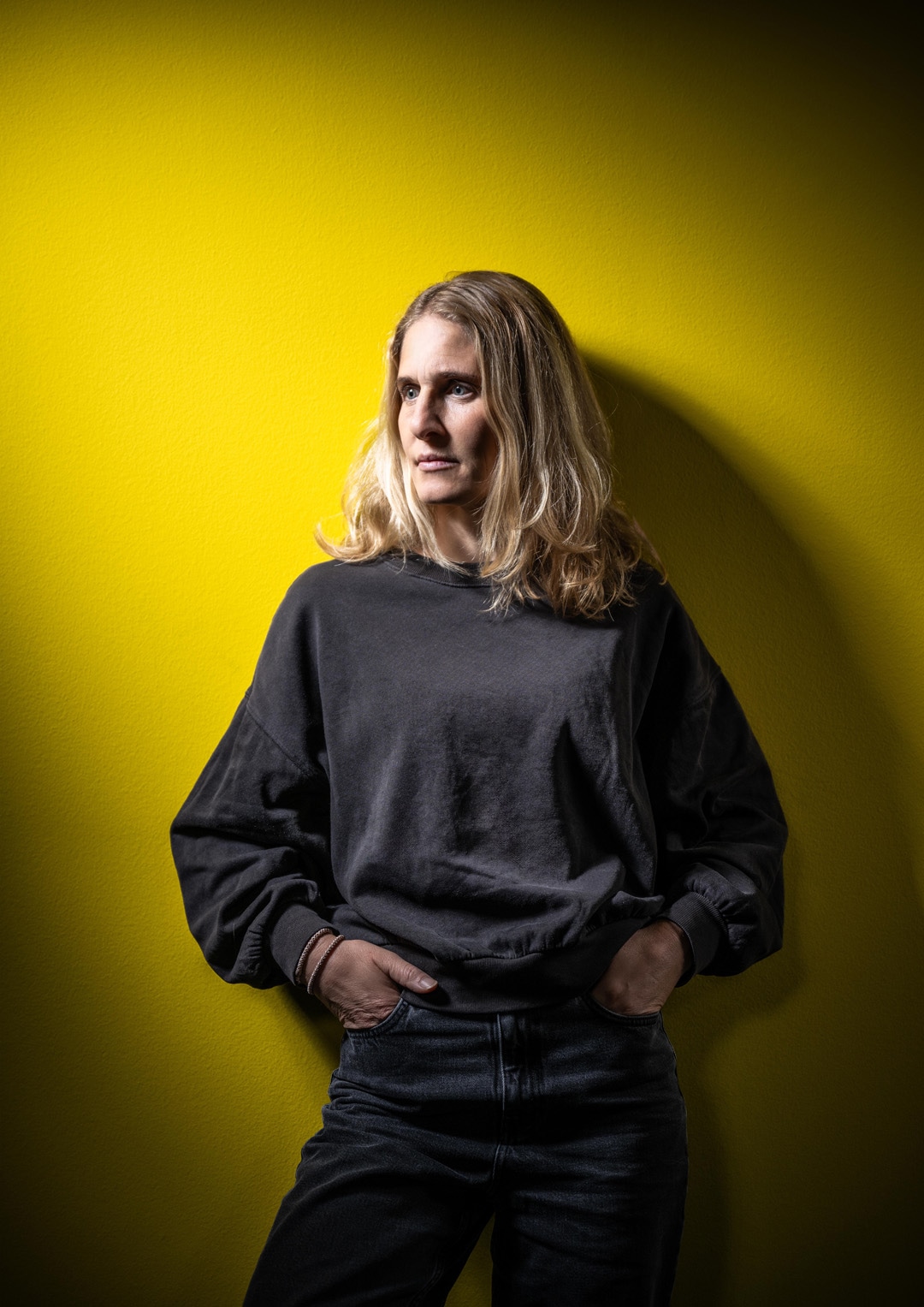 Christa Bühler vor gelbem Hintergrund.