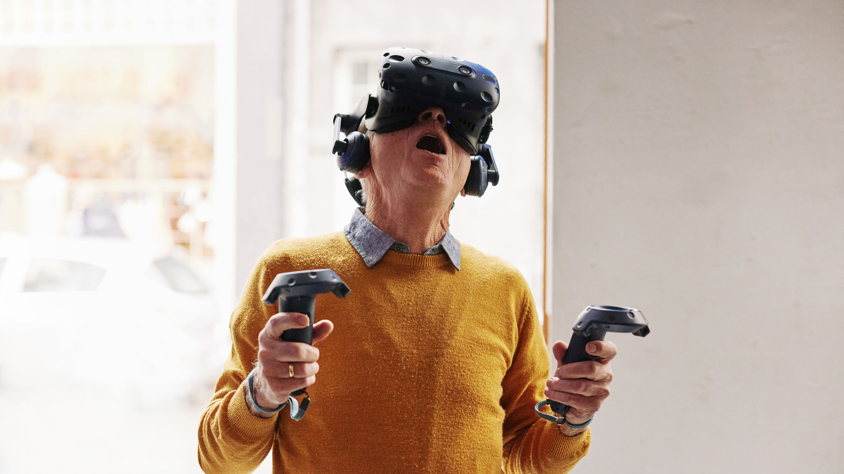 Ein Senior benutzt erstaunt eine futuristisch aussehende VR-Brille der Universität Zürich.