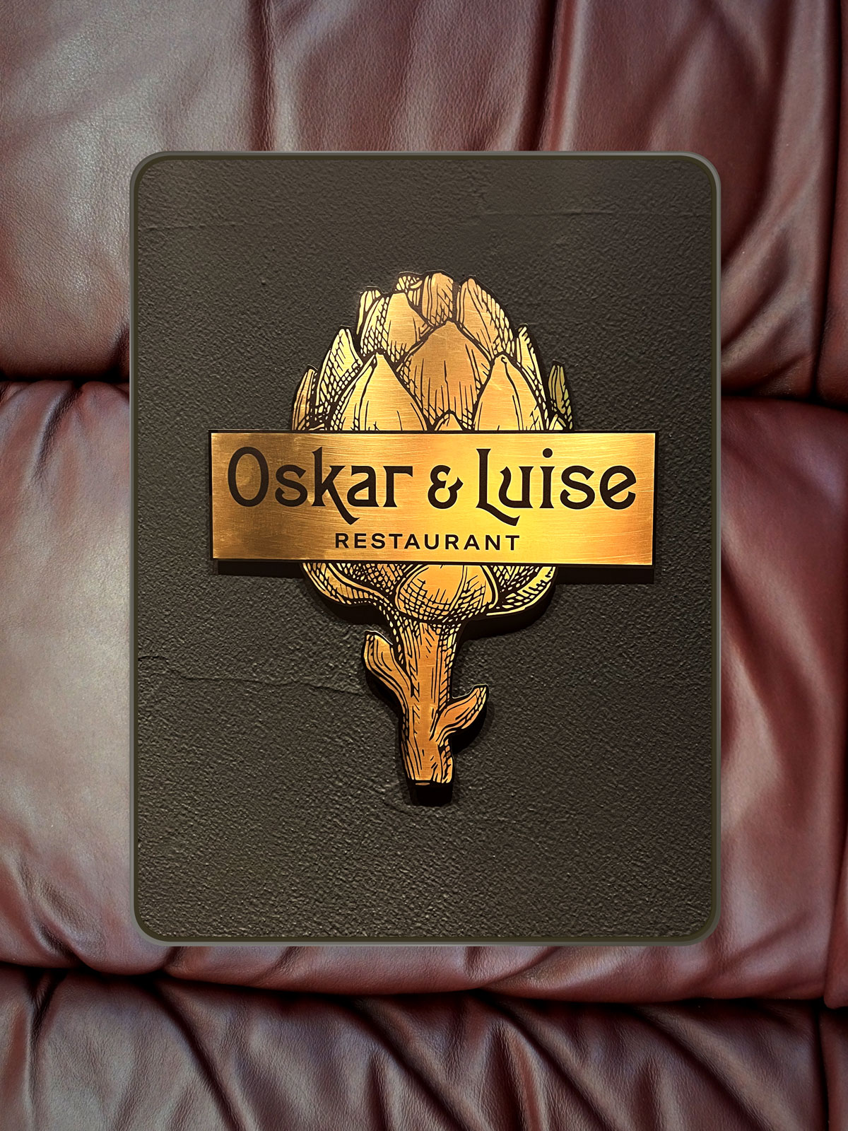 Mockup unserer aktuellen Arbeit für Oskar & Luise: Das Artischocken-Logo in goldener Farbe.